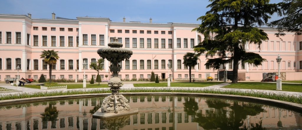 The ornate and grand facade of the Dolmabahçe Palace Harem buildings, viewed from the gardens.